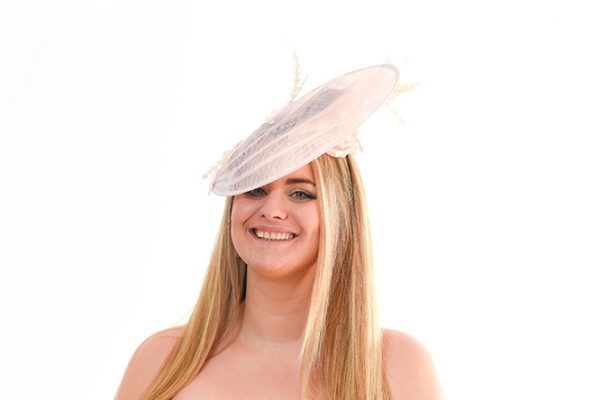 Light Pink Hatinator with underside silk flower visible on the smiling model to the camera